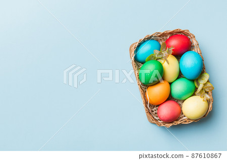 Multi colors Easter eggs in the woven basket on colored background . Pastel color Easter eggs. holiday concept with copy space Multi colors Easter eggs in the woven basket on colored background . Pastel color Easter eggs. holiday concept with copy space 87610867