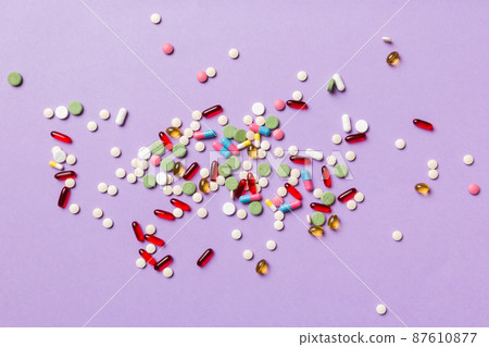 assorted pills and tablets top border over colored background. Many different pills and space for text on colorful background, top view assorted pills and tablets top border over colored background. Many different pills and space for text on colorful background, top view 87610877