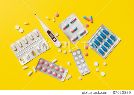 Protective face masks or surgical masks, medicine pills and thermometer on table background. Coronavirus disease. Corona virus concept. Space for text 87610889
