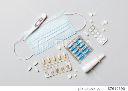 Protective face masks or surgical masks, medicine pills and thermometer on table background. Coronavirus disease. Corona virus concept. Space for text 87610890