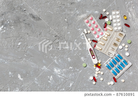 Protective face masks or surgical masks, medicine pills and thermometer on table background. Coronavirus disease. Corona virus concept. Space for text 87610891