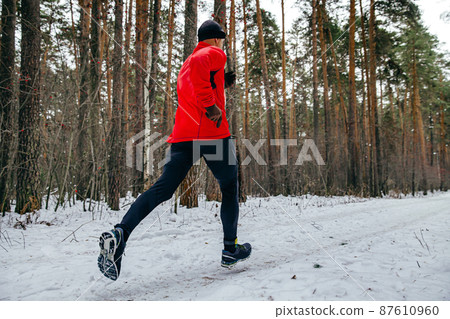 male runner running winter marathon in forest 87610960