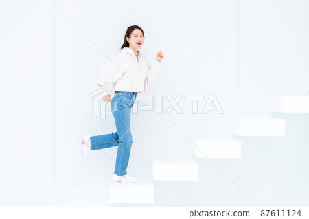 Young woman going up the stairs Young woman going up the stairs 87611124