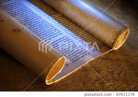Ancient scroll lit by candlelight 87611176