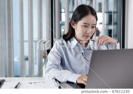 Businesswoman using laptop for financial and accounting work, Using computers to conduct financial transactions because the convenience, Freelancers work, Online communication, Internet, Wireless. Businesswoman using laptop for financial and accounting work, Using computers to conduct financial transactions because the convenience, Freelancers work, Online communication, Internet, Wireless. 87611295