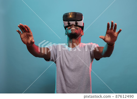 Smiling man looking up and enjoying vr glasses experience Smiling man looking up and enjoying vr glasses experience 87612490