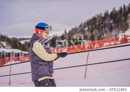 Woman skier climbs a mountain on a ski lift for beginners Woman skier climbs a mountain on a ski lift for beginners 87612861