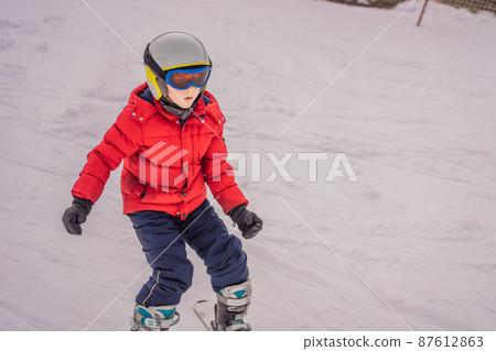 Child skiing in mountains. Active toddler kid with safety helmet, goggles and poles. Ski race for young children. Winter sport for family. Kids ski lesson in alpine school. Little skier racing in snow Child skiing in mountains. Active toddler kid with safety helmet, goggles and poles. Ski race for young children. Winter sport for family. Kids ski lesson in alpine school. Little skier racing in snow 87612863
