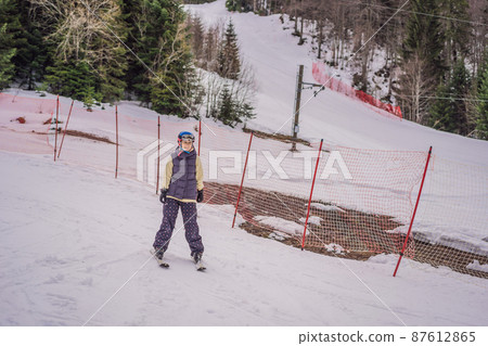 Woman learning to ski. Young woman skiing on a snowy road in the mountains Woman learning to ski. Young woman skiing on a snowy road in the mountains 87612865