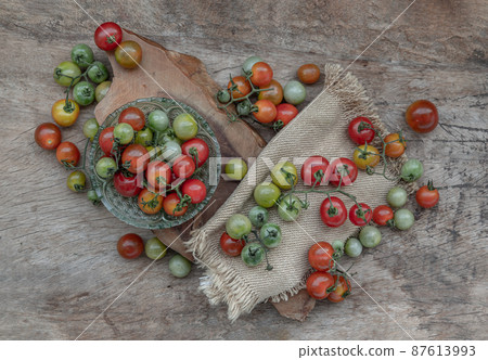 Group of Colorful variety of Fresh wild tomatoes (Mini Cherry Tomatos) on old wooden board background. 87613993
