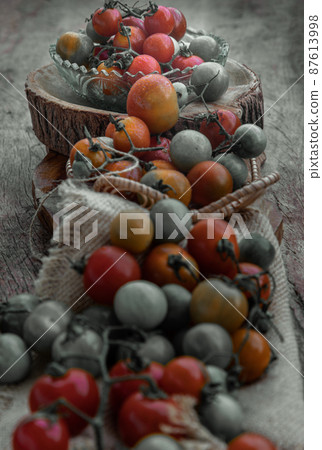Group of Colorful variety of Fresh wild tomatoes (Mini Cherry Tomatos) on old wooden board background. 87613998