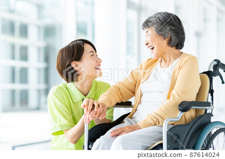 坐輪椅的高級婦女和中級護理人員 坐輪椅的高級婦女和中級護理人員 87614024
