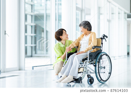 Senior women in wheelchairs and middle care workers 87614103