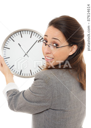 Young woman holding a clock. 87614614