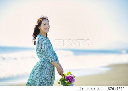 Young woman walking on a sandy beach Young woman walking on a sandy beach 87615211