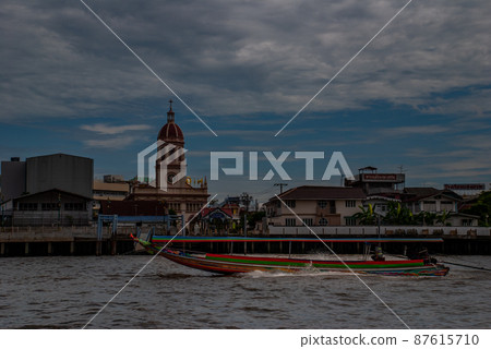 Long-tailed boat rushing on water surface against of Chao Phraya through the Santa Cruz Church in the Kingdom of Thailand. Long-tailed boat rushing on water surface against of Chao Phraya through the Santa Cruz Church in the Kingdom of Thailand. 87615710