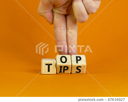 Top tips symbol. Businessman turns wooden cubes with words 'Top tips'. Beautiful orange background. Top tips and business concept. Copy space. Top tips symbol. Businessman turns wooden cubes with words 'Top tips'. Beautiful orange background. Top tips and business concept. Copy space. 87616927