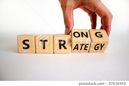 Strong strategy symbol. Businessman turns wooden cubes with words 'strong strategy'. Beautiful white background, copy space. Business and strong strategy concept. Strong strategy symbol. Businessman turns wooden cubes with words 'strong strategy'. Beautiful white background, copy space. Business and strong strategy concept. 87616959