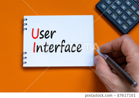 UI user interface symbol. Concept words UI user interface on white note. Businessman hand, calculator. Beautiful orange background. Copy space. Business and UI user interface concept. UI user interface symbol. Concept words UI user interface on white note. Businessman hand, calculator. Beautiful orange background. Copy space. Business and UI user interface concept. 87617101