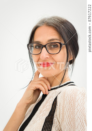 Studio photo of middle aged woman starting getting grey-haired wearing black and white clothes on white background, middle age sexy lady, happy life concept 87617222