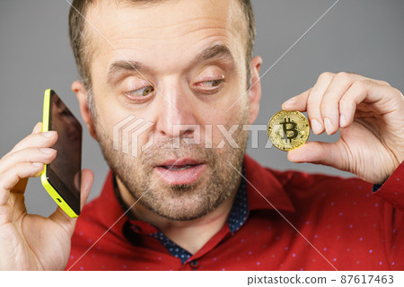 Man with bitcoin talking on phone 87617463