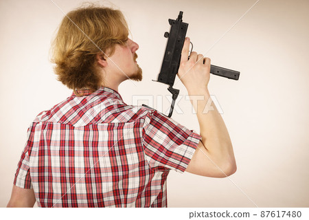 Man standing backwards holding gun Man standing backwards holding gun 87617480
