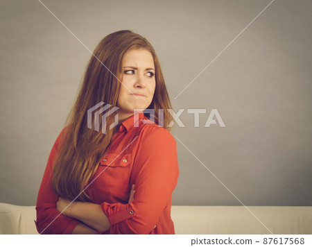 Angry woman sitting on sofa Angry woman sitting on sofa 87617568