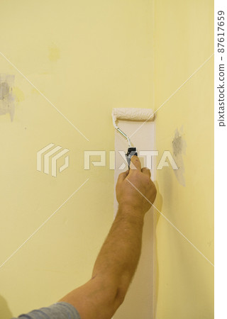 Hand applying paint on wall Hand applying paint on wall 87617659