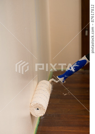 Person applying paint on wall Person applying paint on wall 87617812