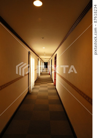 A hotel corridor heading to the back in the dark with nobody A hotel corridor heading to the back in the dark with nobody 87618234