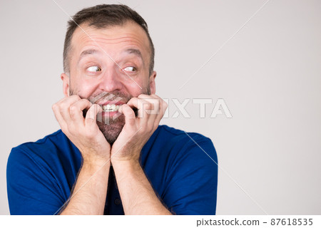 Man biting his nails Man biting his nails 87618535