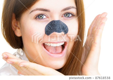 Woman applying pore strips on nose 87618538