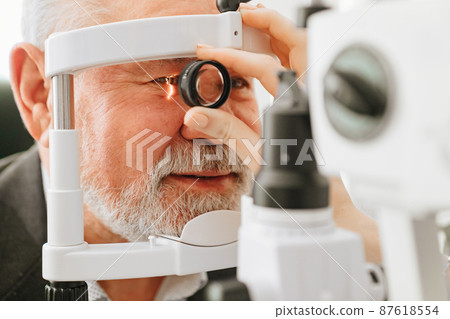 examination of elderly man with slit lamp. medical equipment 87618554