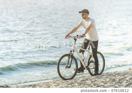 athletic man on a bike ride near the river . athletic man on a bike ride near the river . 87618612