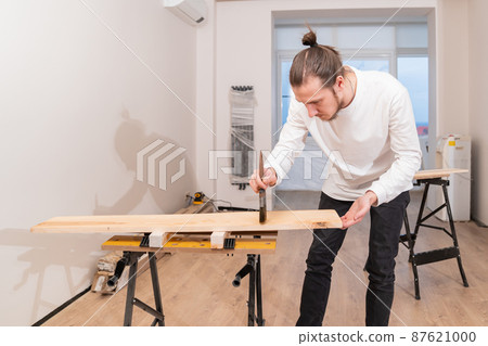 the carpenter covers the wood with oil with a brush. the carpenter covers the wood with oil with a brush. 87621000