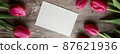 Pink Tulips and gift card on a wooden background. Space for the text. Top view 87621936