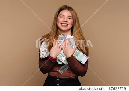 Girl with closed eyes holds bunch paper money 87622729
