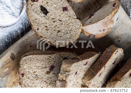 fresh cut bread made of flour and dried cranberries 87623752