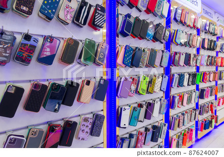 Berlin, Germany - March 10, 2022: Different mobile phone cases on shelves in a store. Berlin, Germany - March 10, 2022: Different mobile phone cases on shelves in a store. 87624007