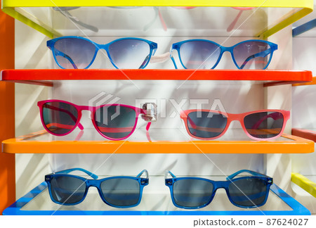 Beautiful multi-color sunglasses in modern optic shop. Several trendy stylish glasses. Beautiful multi-color sunglasses in modern optic shop. Several trendy stylish glasses. 87624027