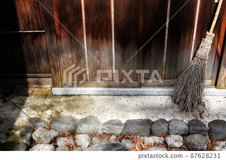 Bamboo broom leaning against the wall of the hut Bamboo broom leaning against the wall of the hut 87628231