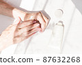 Senior lady, woman with a beautiful, natural, pink, beige manicure  moisturizing hand cream. 87632268