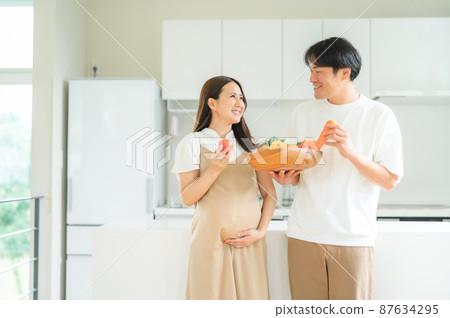 Pregnant women and men with vegetables Pregnant women and men with vegetables 87634295
