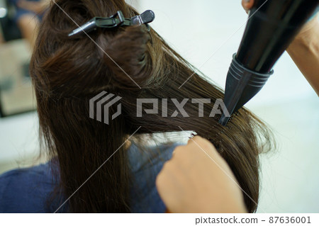 Asian young woman have a hair cutting and spa by professional beauty hair dresser. Woman sitting on the chair in beauty - Salon shop while barber cutting her hair. Asian young woman have a hair cutting and spa by professional beauty hair dresser. Woman sitting on the chair in beauty - Salon shop while barber cutting her hair. 87636001
