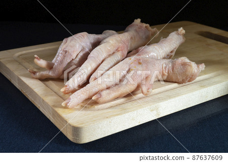 Chicken paws on wooden board on table Chicken paws on wooden board on table 87637609