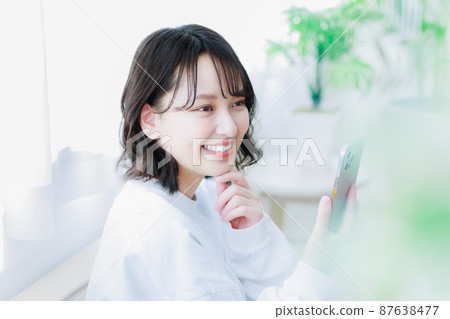 Young woman using a smartphone 87638477