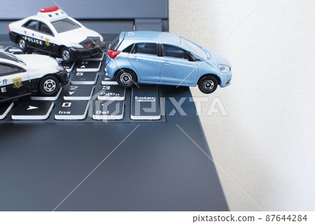 黑鍵盤、兩輛警車和一輛淺藍色緊湊型汽車 87644284
