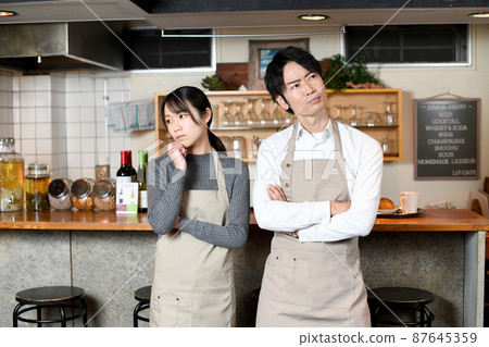 Asian male and female clerk worried at a restaurant 87645359