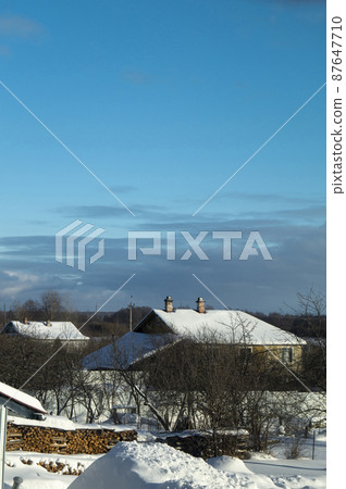 Winter in village on turn blue background Winter in village on turn blue background 87647710