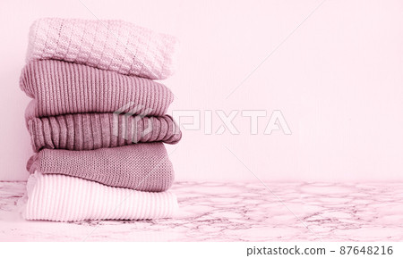 Stack of knitted wool pink warm sweaters 87648216